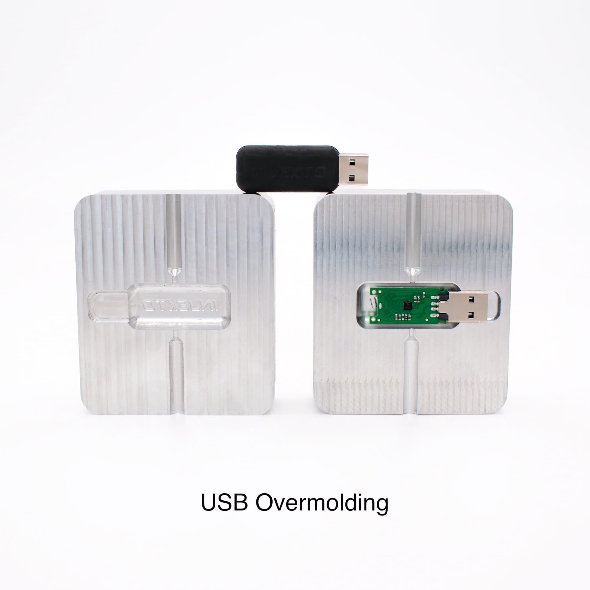 Aluminum mold blank machined into a USB overmolding tool, with the USB PCB loaded in the cavity and the finished overmolded drive above.